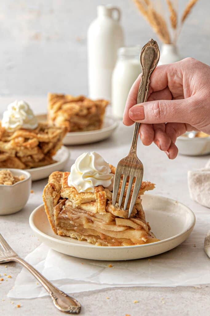 A fork in hand, digging into a slice of apple pie.