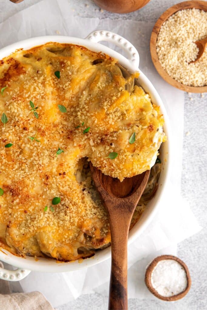 Potatoes au gratin in a casserole dish with a serving spoon.