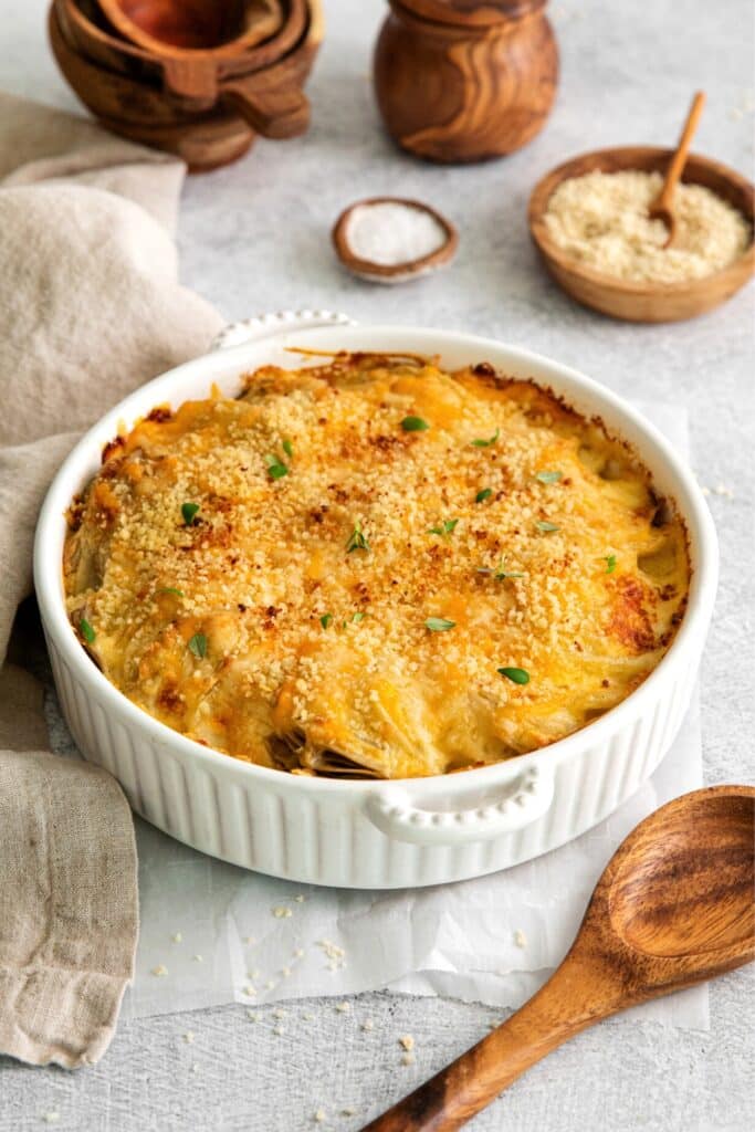 Potatoes au Gratin with Gruyere baked in a round, white casserole dish.