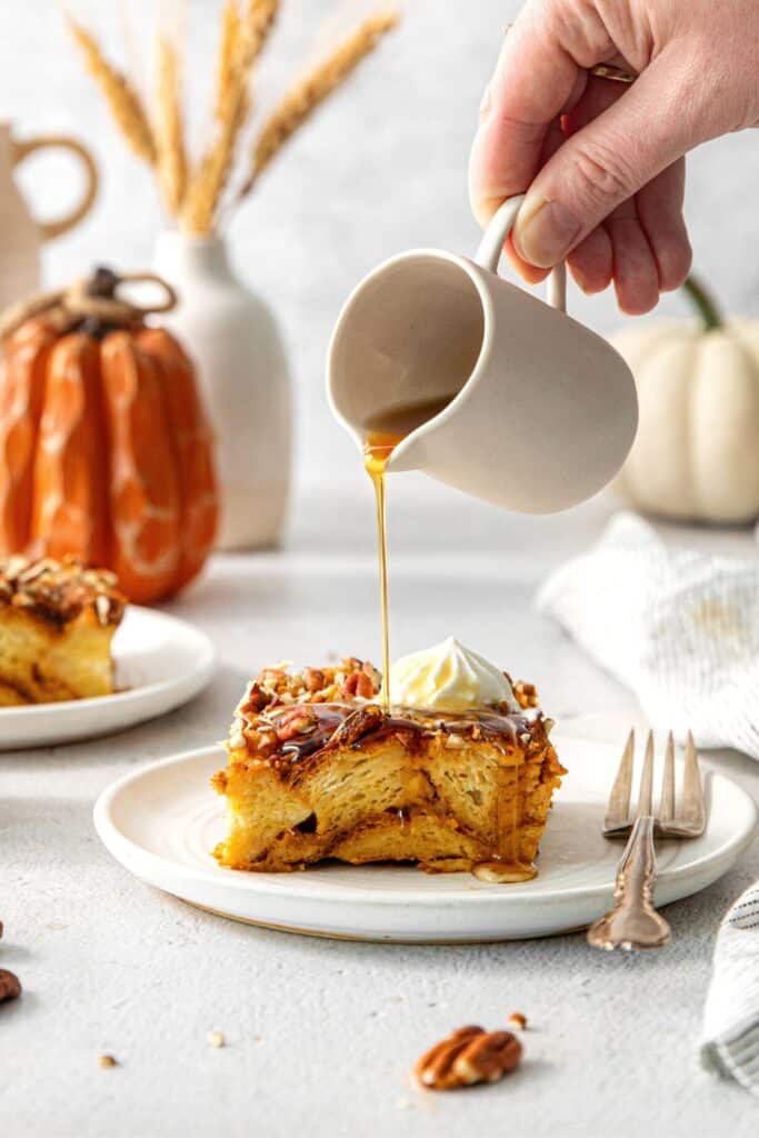 A delicious serving of pumpkin bread pudding on a dessert plate with fork.