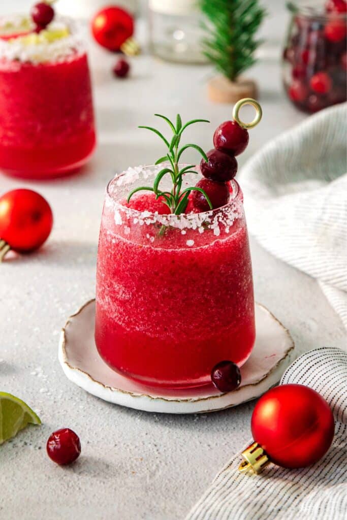 Cranberry tequila cocktail garnished with fresh cranberries and rosemary.