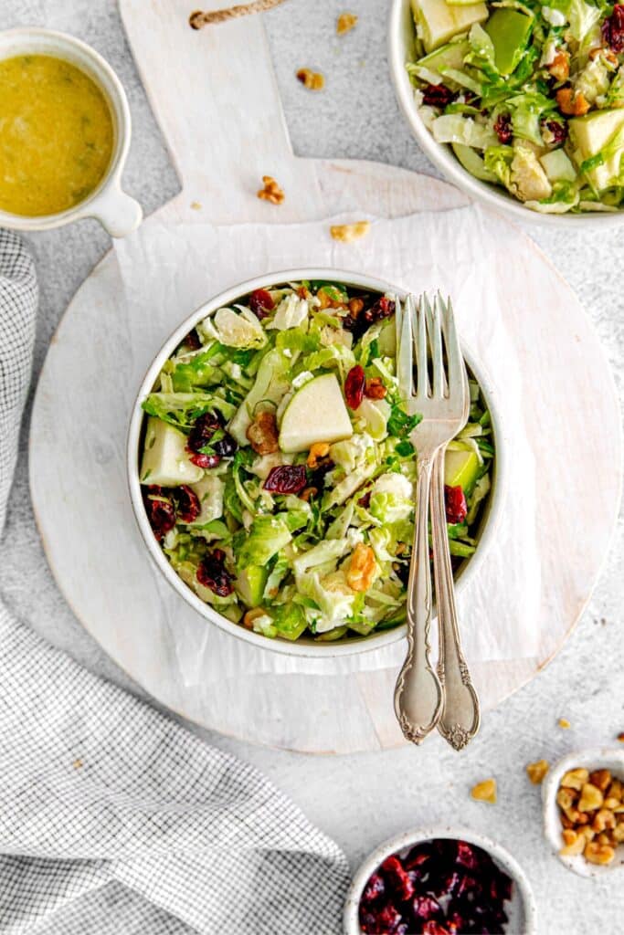 Shaved Brussels sprout salad on a table with forks.