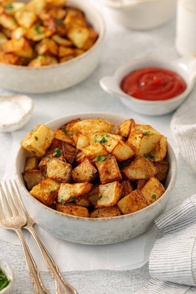 Crispy air fryer breakfast potatoes served with ketchup on the side.