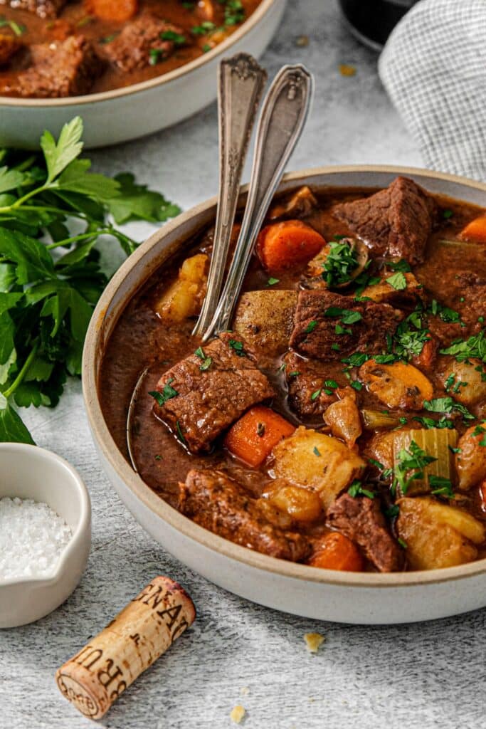 A bowl of old-fashioned beef and potato stew made in a Dutch oven.