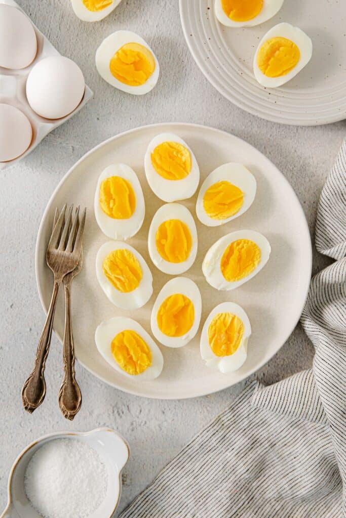 Air fryer soft boiled eggs on a breakfast platter, sliced in half.