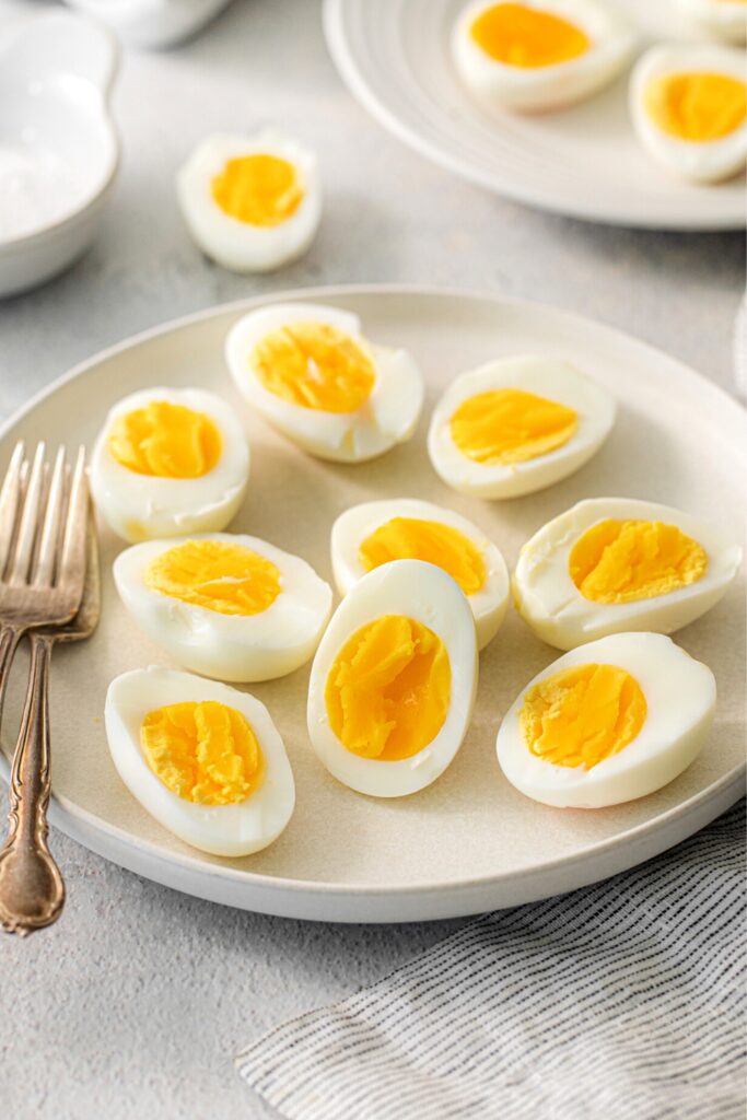A serving plate of air fryer hard boiled eggs sliced in half.