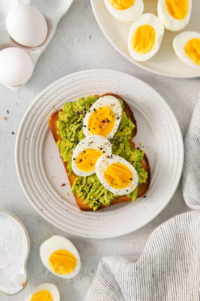 Air fryer soft boiled eggs served on a plate with avocado toast.