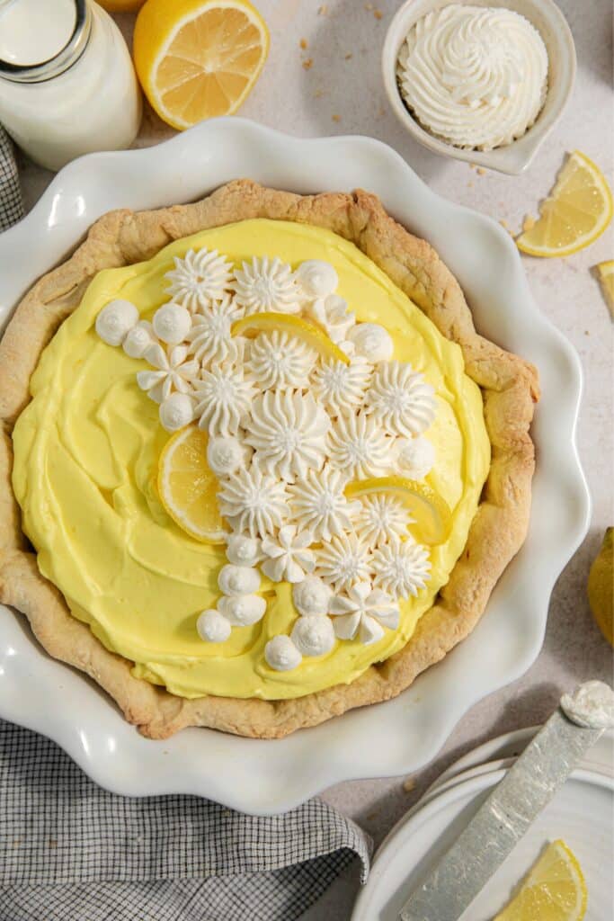 Lemon pie with dollops of whipped cream piped over the surface.