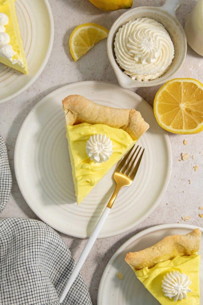 Slice of lemon pie on a dessert plate with a fork.