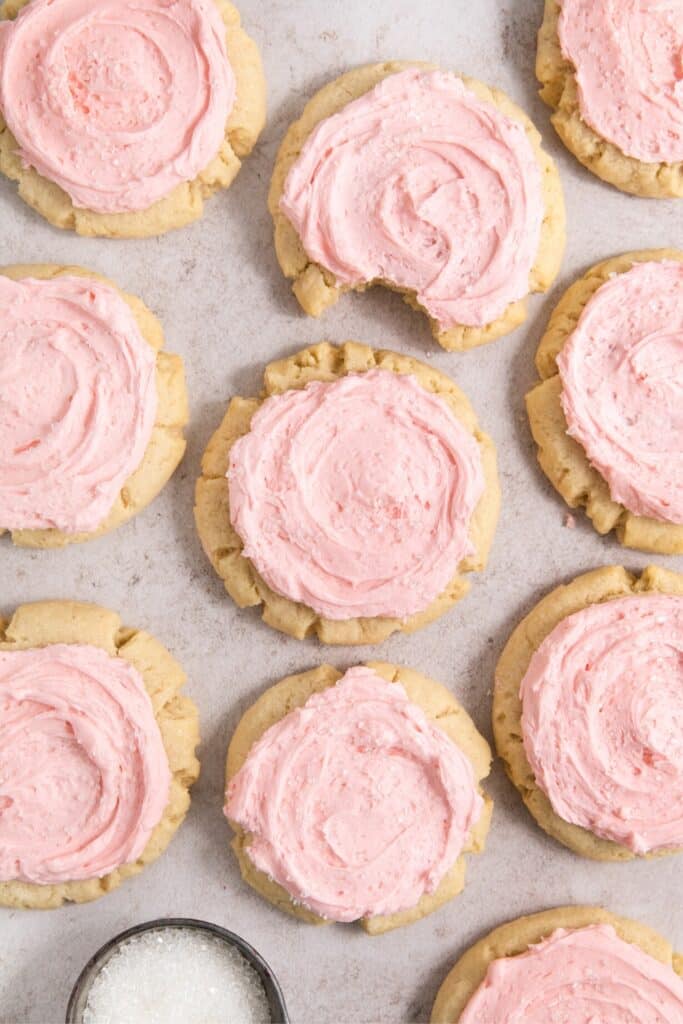 A batch of pink frosted sugar cookies.